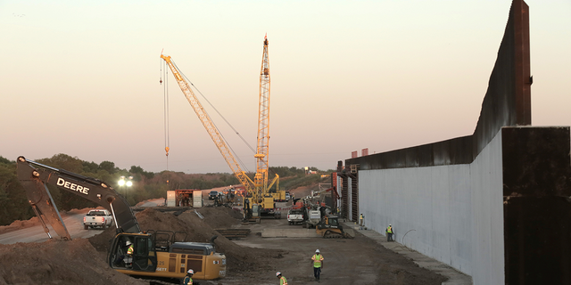Workers continue the assembly at the Mission Levee Phase II border wall construction site off Abram Road in Mission, Texas, Oct. 6, 2021.