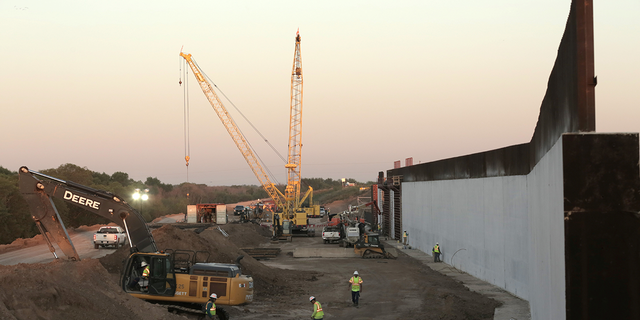 Workers continue the assembly at the Mission Levee Phase II border wall construction site off Abram Road in Mission, Texas, Oct. 6, 2021.