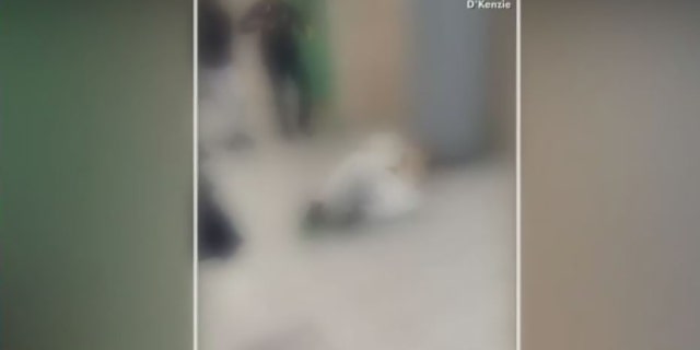 In this blurred video to protect the identities of minors, a student lies on the floor after officers appeared to pepper-spray and use a stun gun on him.