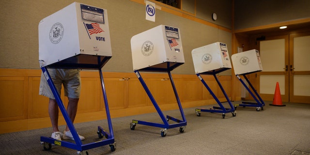 A voter stands in a booth at a voting station at the Metropolitan Museum of Art (MET) during the mayoral election process in New York on June 12, 2021. 