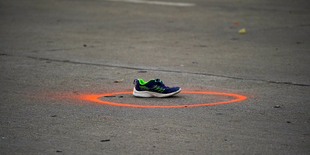 A shoe circled in spray paint to mark as evidence are seen on Main Street the morning after a car plowed through a holiday parade in Waukesha, Wisconsin, U.S., November 22, 2021. REUTERS/Cheney Orr