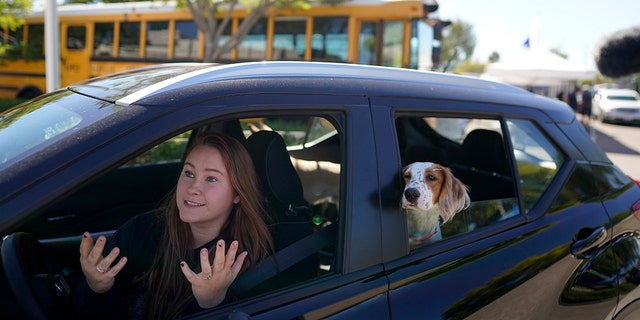 Brooklyn Pittman talks as she sits in her car with her dogs after receiving food from an Armed Services YMCA food distribution on Oct. 28 in San Diego. 