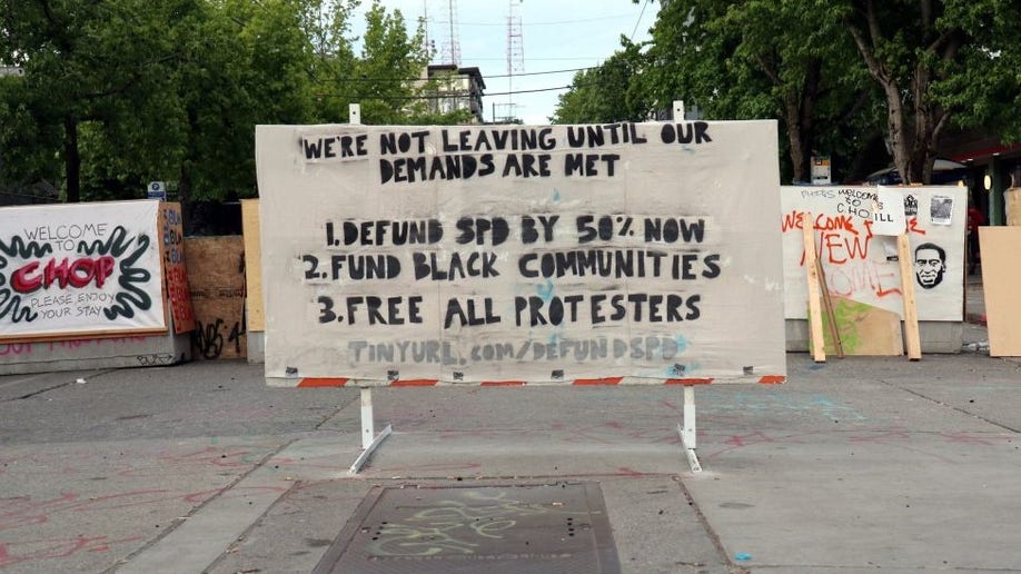 A placard outside the western wall of Seattle's Capitol Hill Occupied Protest (CHOP) zone lists protester demands. 