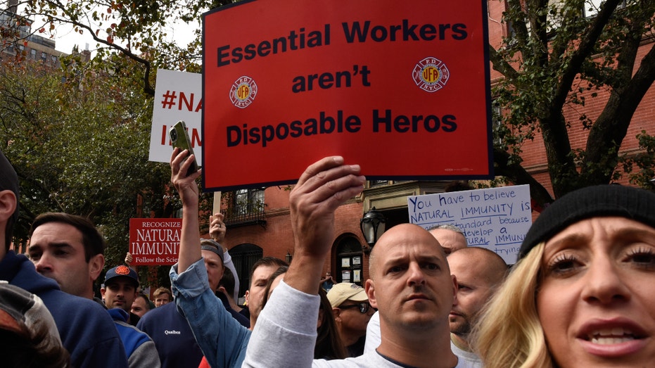 Demonstrators hold signs during a protest against the New York City COVID-19 vaccine mandate. Photographer: Stephanie Keith/Bloomberg