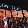 Demonstrators hold placards during a protest against the Kyle Rittenhouse not-guilty verdict near the Barclays Center in New York on November 19, 2021.