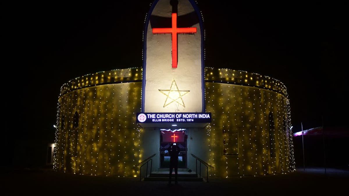A devotee takes pictures of the illuminated CNI Church ahead of Christmas celebrations in Ahmedabad on Dec. 22, 2021.