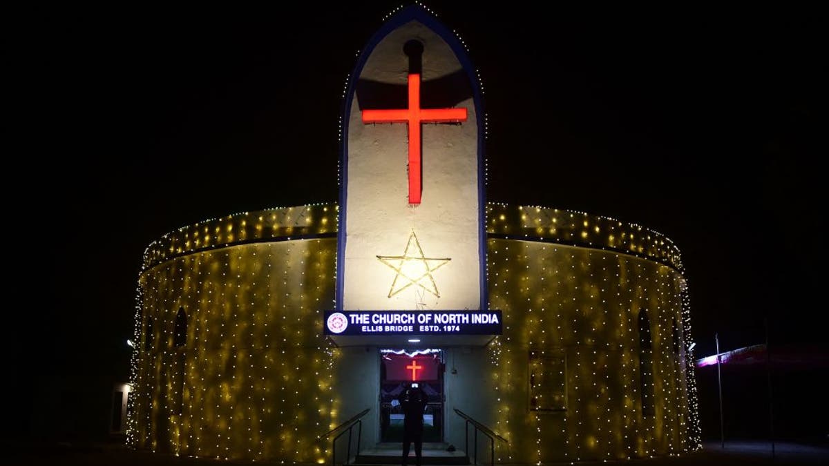 A devotee takes pictures of the illuminated CNI Church ahead of Christmas celebrations in Ahmedabad on Dec. 22, 2021.