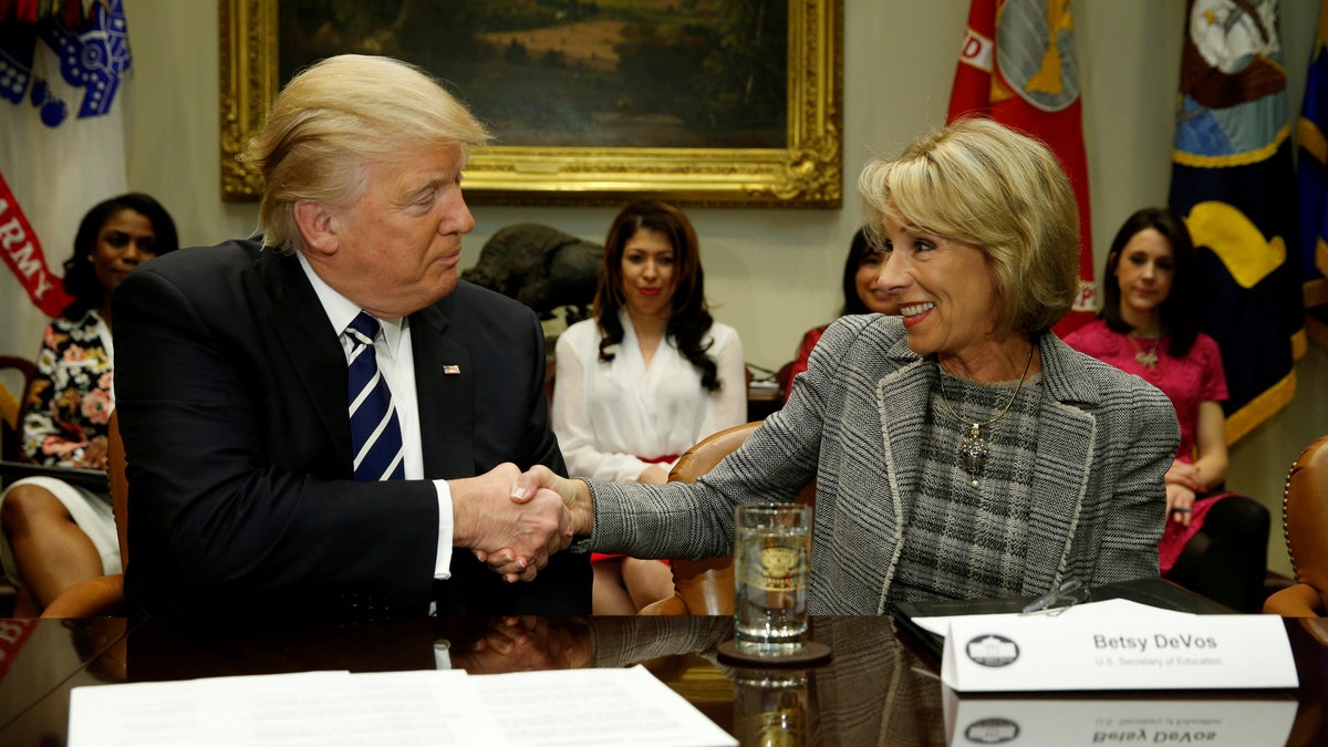 President Donald Trump congratulates Education Secretary Betsy DeVos on her confirmation at the White House on Feb. 14, 2017. REUTERS/Kevin Lamarque /File Photo