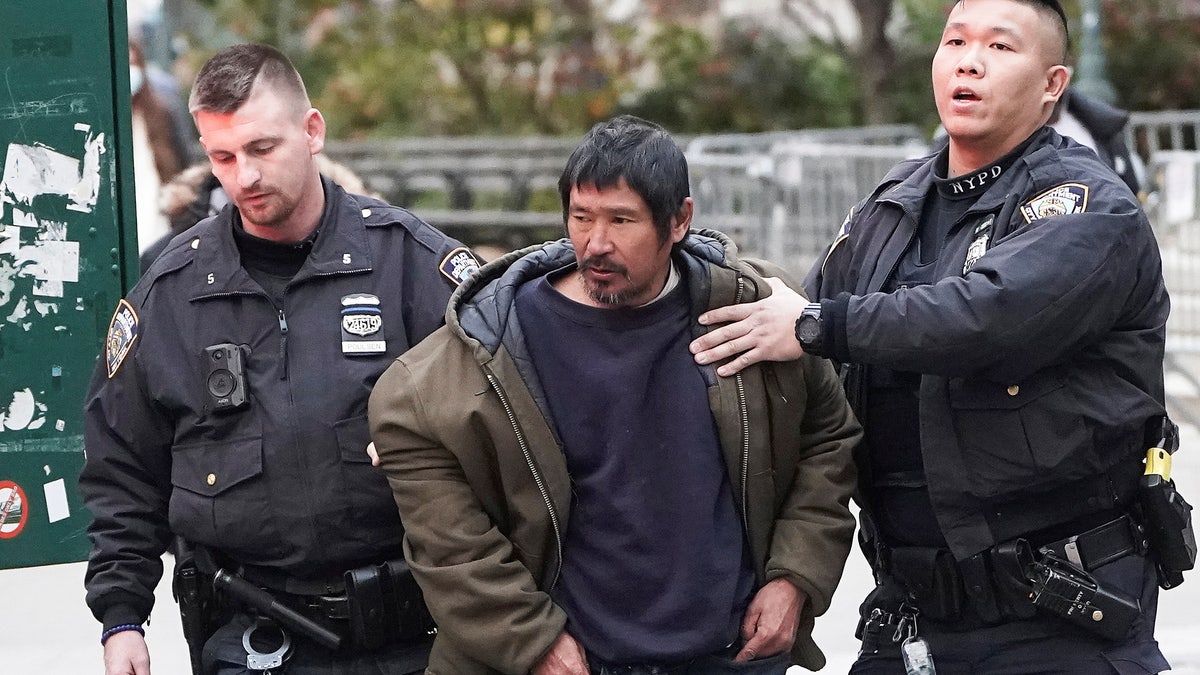 Craig Tamanaha, who was later charged with setting fire to a Christmas tree outside the Fox News headquarters, is detained by police after exposing himself outside the court at the trial of Ghislaine Maxwell in the Manhattan borough of New York City, Nov. 29, 2021. 