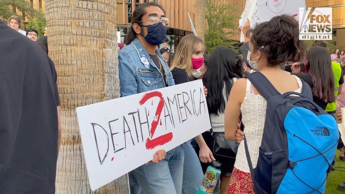 A protester holds a "Death to America" sign at a rally protesting Kyle Rittenhouse at Arizona State University.