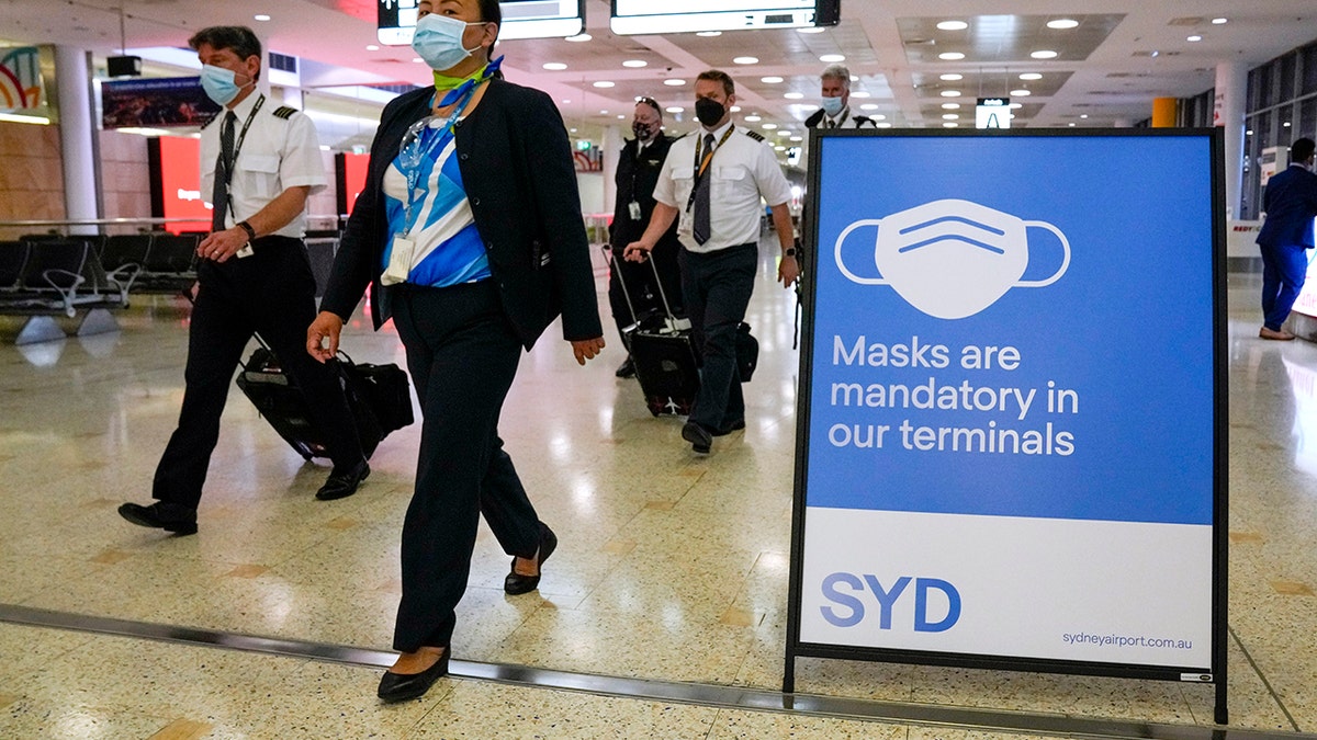 FILE - A flight crew walk through the terminal at Sydney Airport on Nov. 29, 2021.?