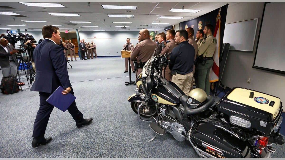 Gov. Ron DeSantis arrives to announce a proposal for an increase in pay for state law enforcement agencies to encourage more officers to relocate to Florida, during a press conference. (Joe Burbank/Orlando Sentinel via AP)