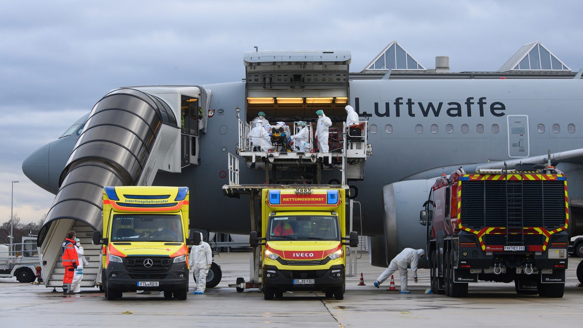 A COVID-19 patient is transported by Bundeswehr medical personnel to an A310 MedEvac aircraft of the German Air Force at Dresden International Airport, Germany, Wednesday, Dec. 1, 2021. (Robert Michael/dpa via AP)