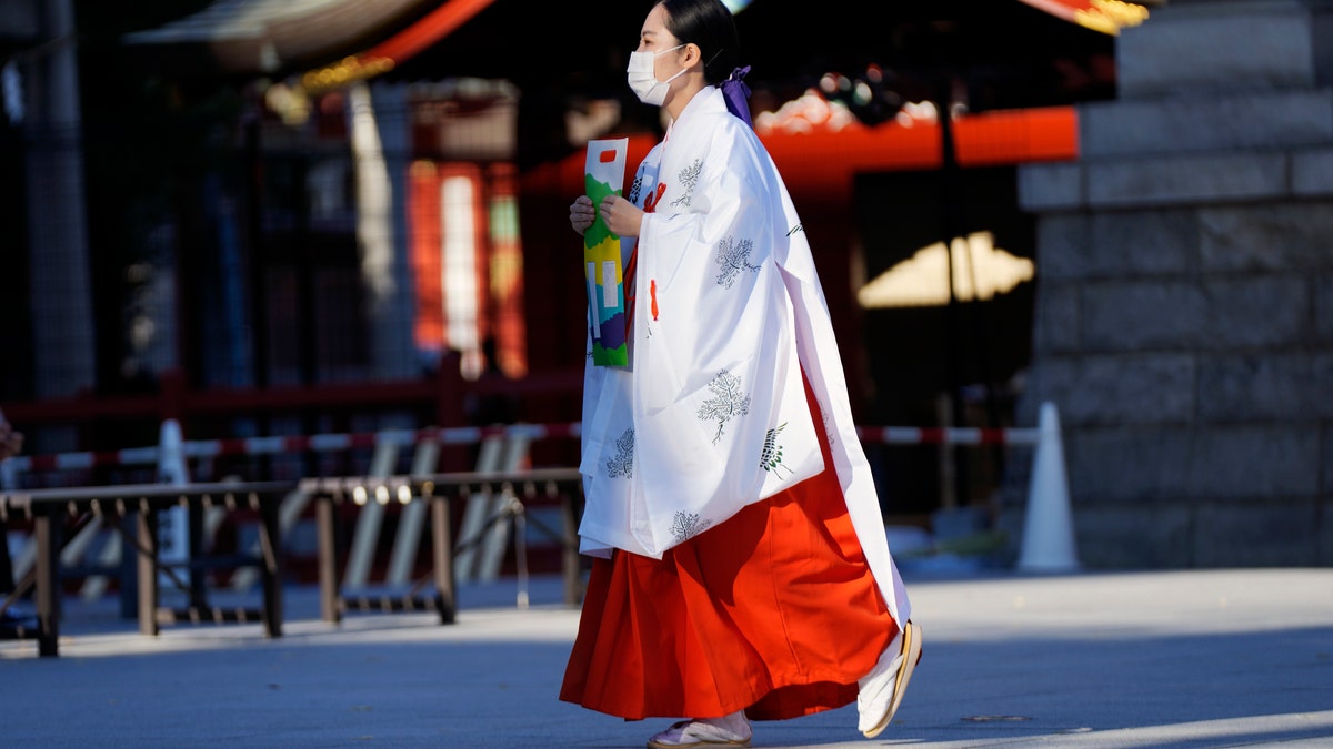 A miko, or shrine maiden, wearing a protective mask to help curb the spread of the coronavirus. (AP Photo/Eugene Hoshiko)