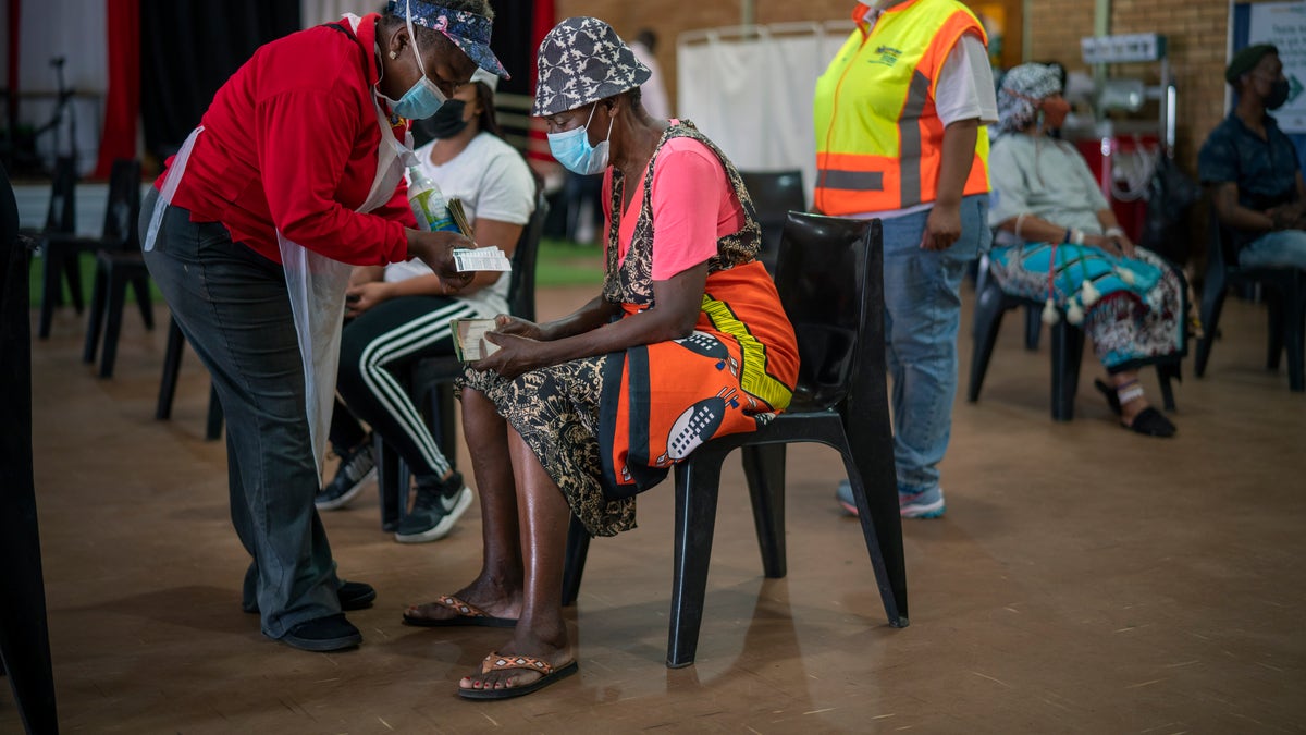 An Orange Farm, South Africa, resident listens to a nurse after receiving his jab against COVID-19 Friday Dec. 3, 2021 at the Orange Farm multipurpose center. South Africa has accelerated its vaccination campaign a week after the discovery of the omicron variant of the coronavirus. (AP Photo/Jerome Delay)