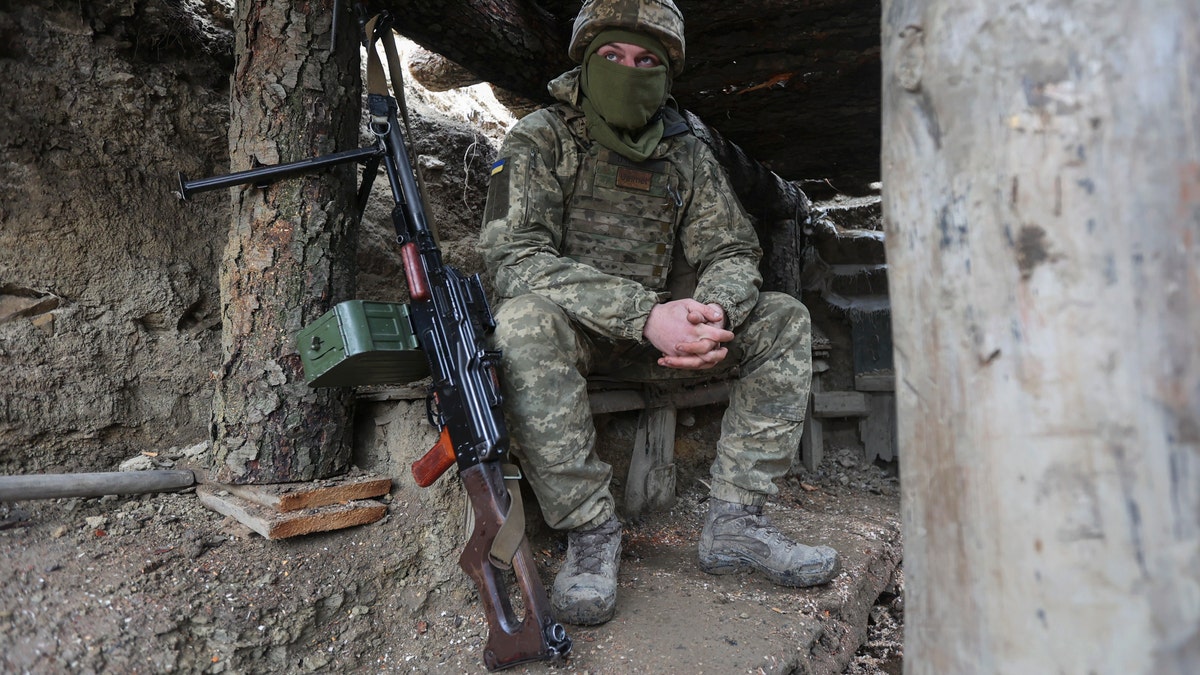 Ukrainian soldiers sits in a fighting position on the line of separation from pro-Russian rebels near Debaltsevo, Donetsk region, Ukraine, Ukraine Friday, Dec 3, 2021. In this Friday, the Ukrainian defense minister warned that Russia could invade his country next month. Russia-West tensions escalated recently with Ukraine and its Western backers becoming increasingly concerned that a Russian troop buildup near the Ukrainian border could signal Moscow's intention to invade. (AP Photo/Andriy Dubchak)