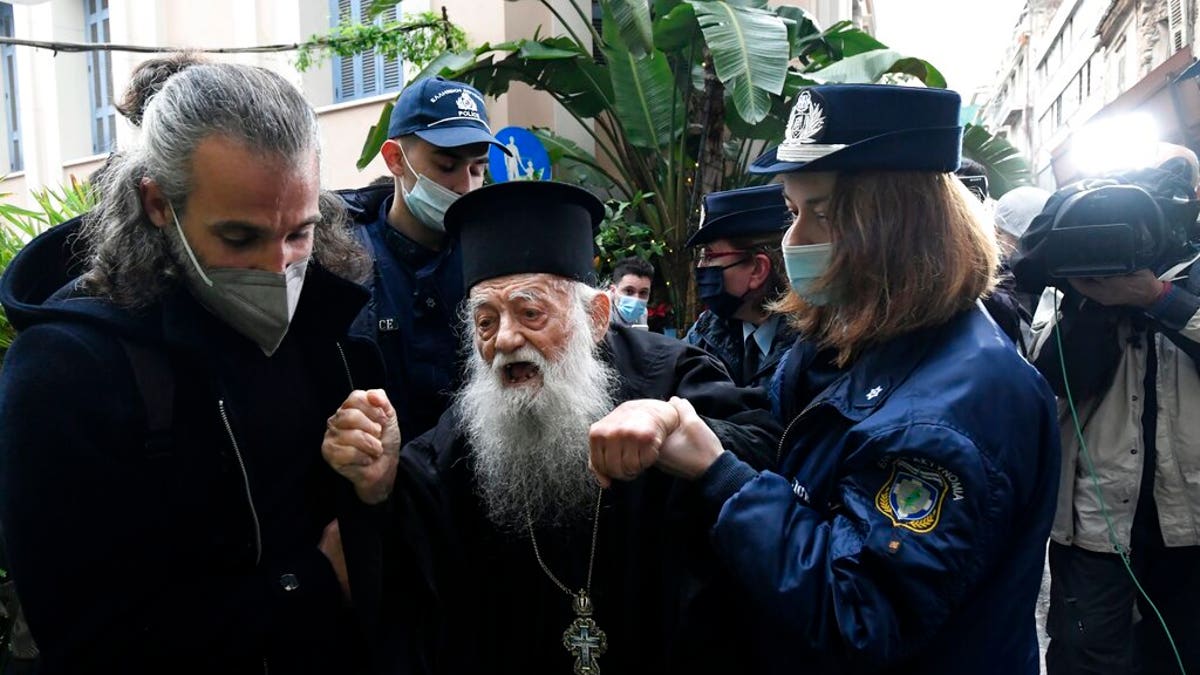 Police hold a protesting Orthodox Priest during the visit of Pope Francis at the Archbishopric of Greece in Athens, Saturday, Dec. 4, 2021. Pope Francis warned Saturday that the "easy answers" of populism and authoritarianism threaten democracy in Europe and called for fresh dedication to promoting the common good. (AP Photo/Michael Varaklas)
