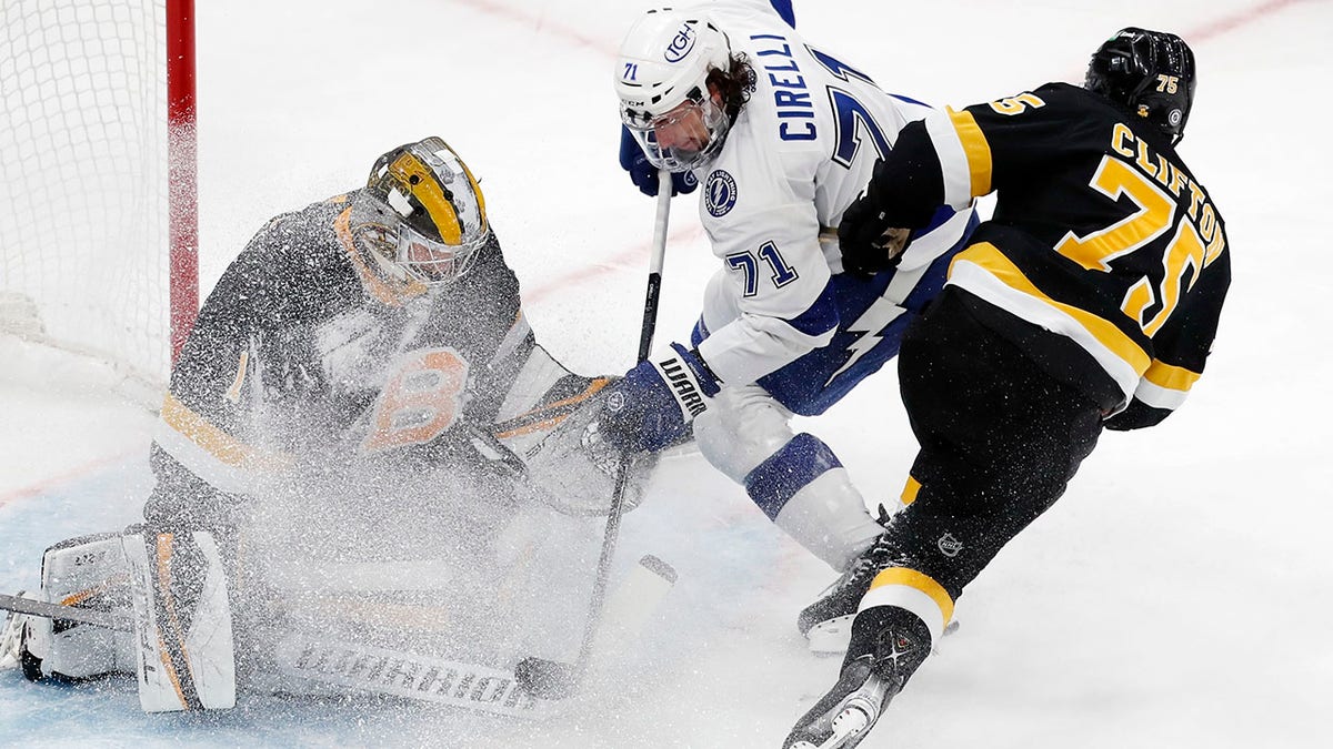 Boston Bruins' Jeremy Swayman (1) blocks a shot by Tampa Bay Lightning's Anthony Cirelli (71) as Connor Clifton (75) defends during the third period of an NHL hockey game, Saturday, Dec. 4, 2021, in Boston.