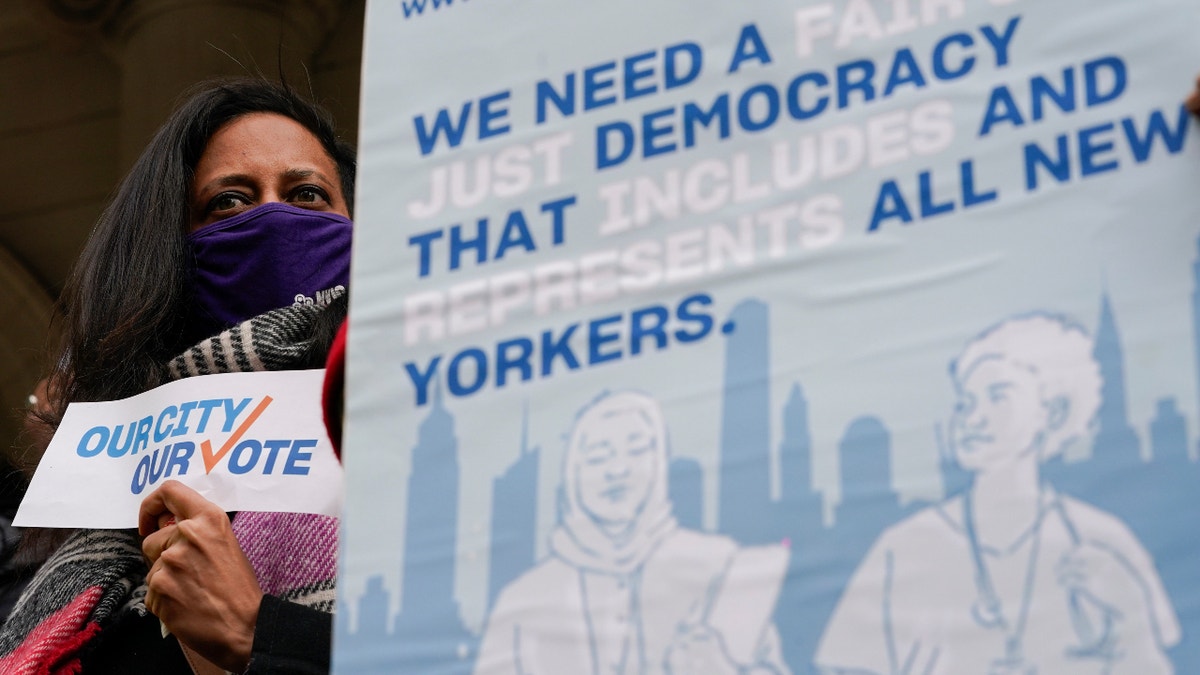 Activists participate in a rally on the steps of City Hall ahead of a City Council vote to allow lawful permanent residents to cast votes in elections to pick the mayor, City Council members and other municipal officeholders, Thursday, Dec. 9, 2021, in New York. (AP Photo/Mary Altaffer)