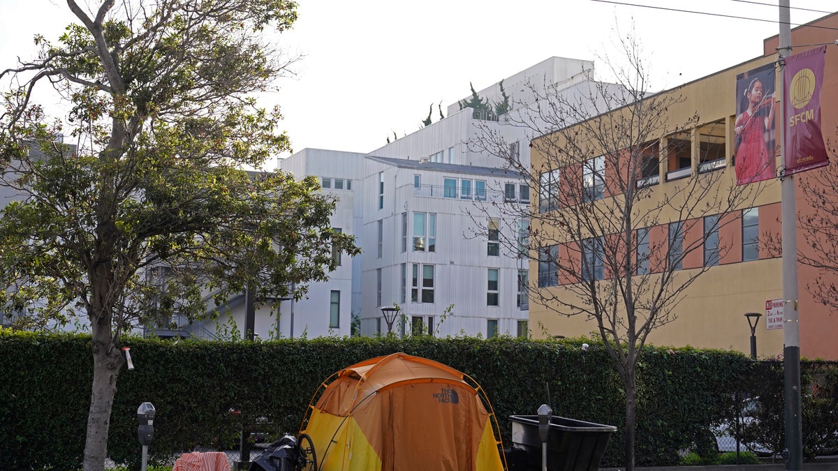A tent is seen on a sidewalk just around the corner from the Opera House with a residential building in the background in San Francisco, Thursday, Dec. 2, 2021. (AP Photo/Eric Risberg)