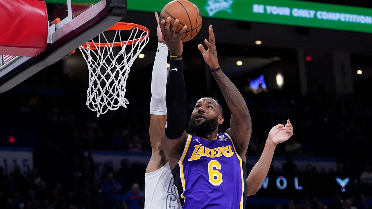 Los Angeles Lakers forward LeBron James (6) goes to the basket in front of Oklahoma City Thunder forward Darius Bazley during the first half of an NBA basketball game Friday, Dec. 10, 2021, in Oklahoma City.