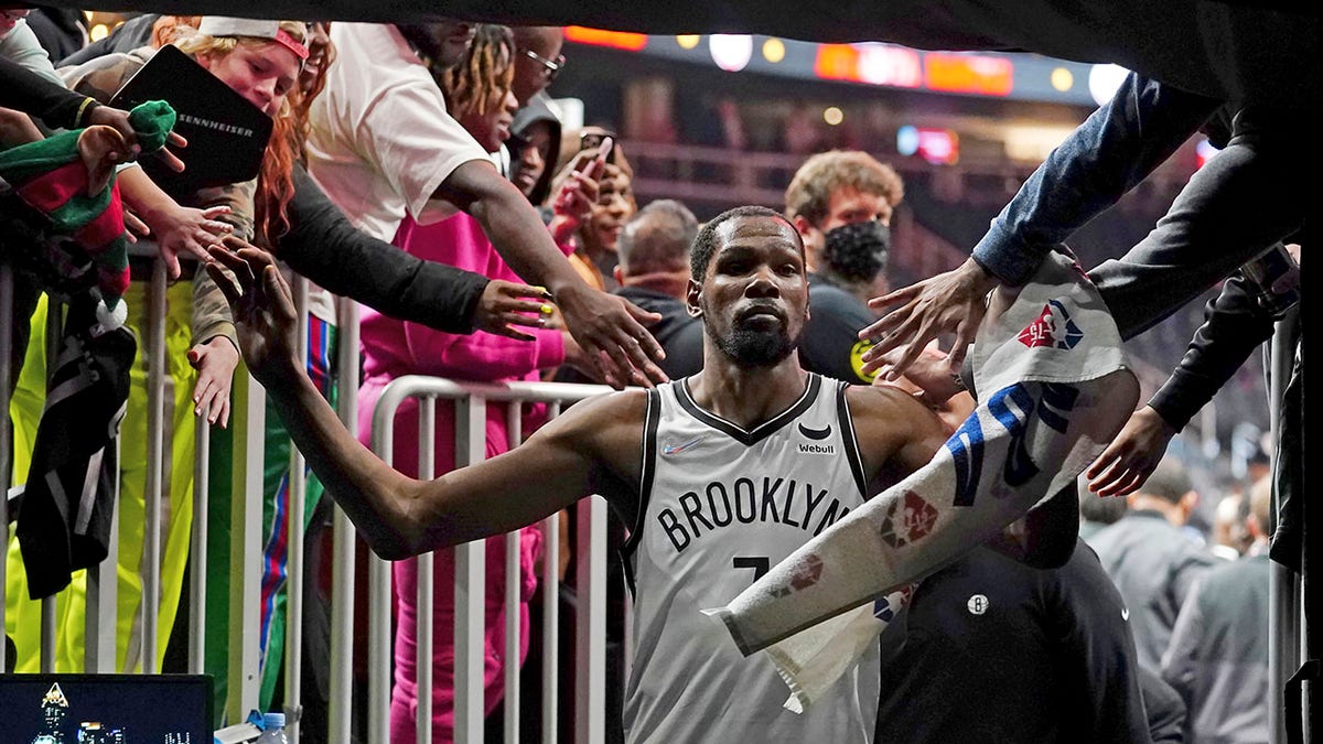 Brooklyn Nets forward Kevin Durant (7) makes his way past fans as he walks to the locker room after the Nets defeated the Atlanta Hawks in an NBA basketball game Friday, Dec. 10, 2021, in Atlanta.