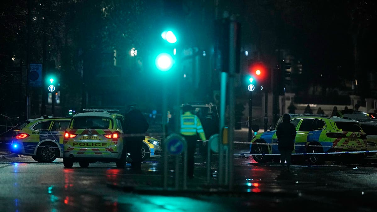 Police attend the scene near Kensington High Street in London, Saturday Dec. 11, 2021. (Aaron Chown/PA via AP)
