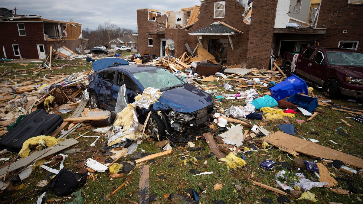 A car sits in the debris caused by a tornado in Bowling Green, Ky., Saturday, Dec. 11, 2021. A monstrous tornado killed dozens of people in Kentucky and the toll was climbing Saturday after severe weather ripped through at least five states, leaving widespread devastation. (AP Photo/Michael Clubb)