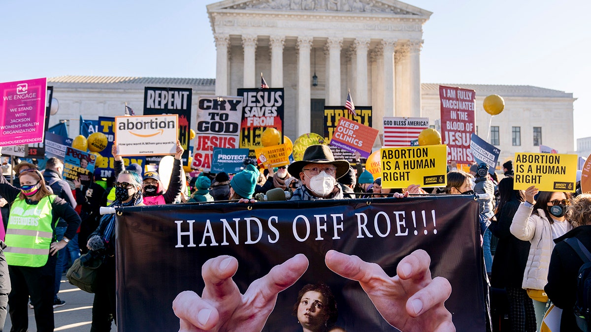Stephen Parlato of Boulder, Colorado, holds a sign that reads "Hands Off Roe!!!" as abortion rights advocates and anti-abortion protesters demonstrate in front of the U.S. Supreme Court, Dec. 1, 2021, in Washington.