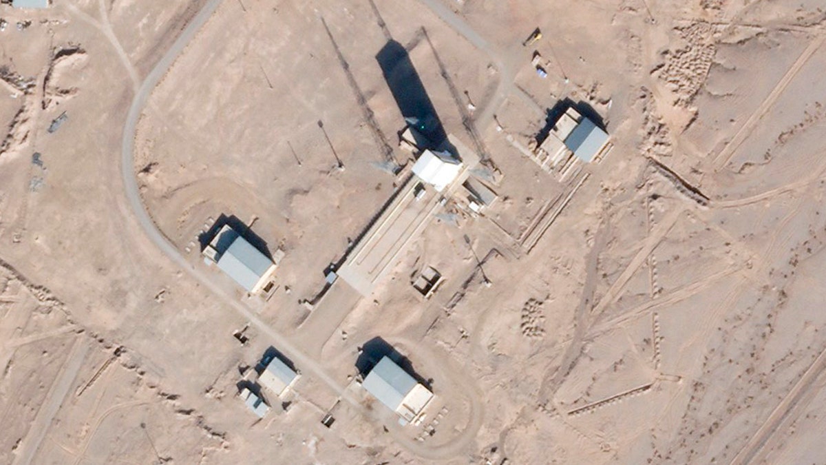 In this satellite photo by Planet Labs Inc., a support vehicle stands parked alongside a massive white gantry that typically houses a rocket on the launch pad as activity is seen at the Imam Khomeini Spaceport in Semnan province, Iran, Saturday, Dec. 11, 2021.  (Planet Labs Inc. via AP)