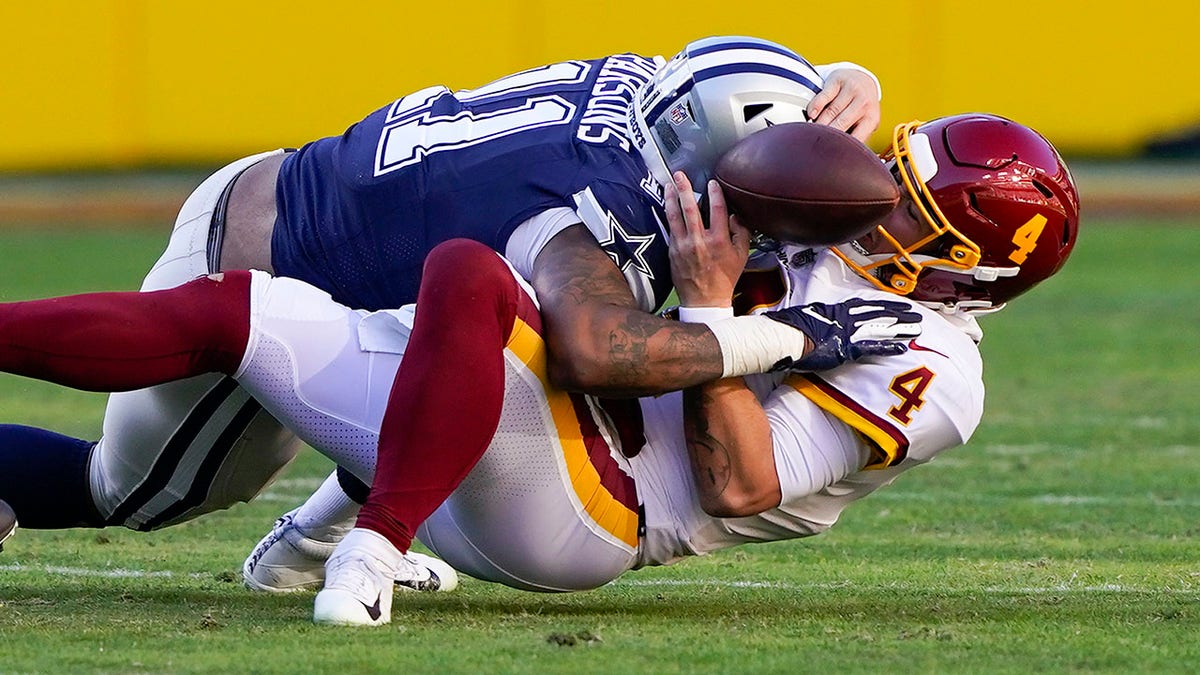 Washington Football Team quarterback Taylor Heinicke (4) fumbles the ball as he is sacked by Dallas Cowboys outside linebacker Micah Parsons (11) during the first half of an NFL football game, Sunday, Dec. 12, 2021, in Landover, Md. Dallas recovered the ball and scored a touchdown on this play.