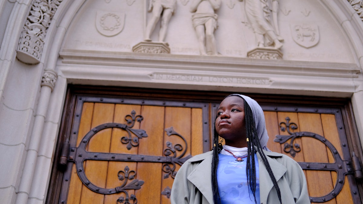 Nathalie Charles poses for a portrait outside the Princeton University Chapel in Princeton, N.J. on Wednesday, Dec. 8, 2021. Charles left her Baptist church at the age of 15 because as a queer woman of Haitian descent, she felt unwelcome in her congregation. (AP Photo/Luis Andres Henao)