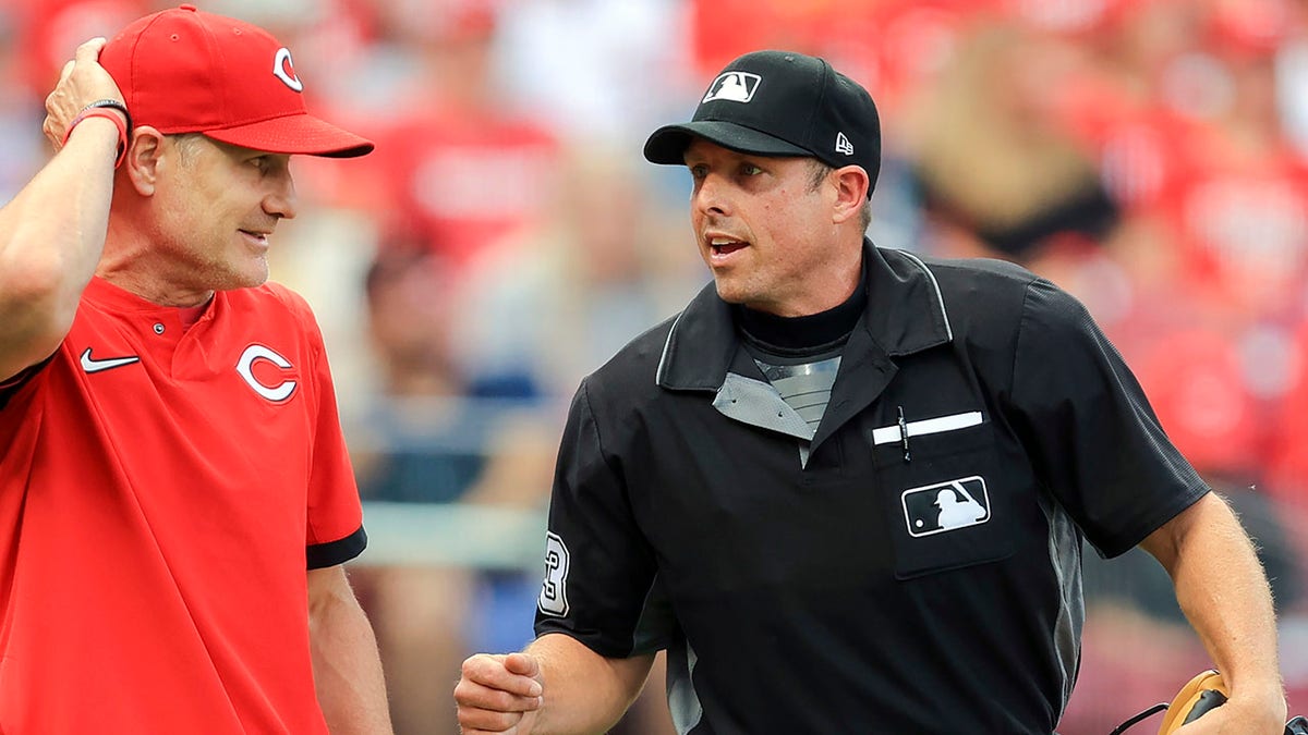 Cincinnati Reds manager David Bell, left, talks with umpire Tripp Gibson, right, between batters during the first inning of a baseball game against the San Diego Padres in Cincinnati, July 1, 2021. 