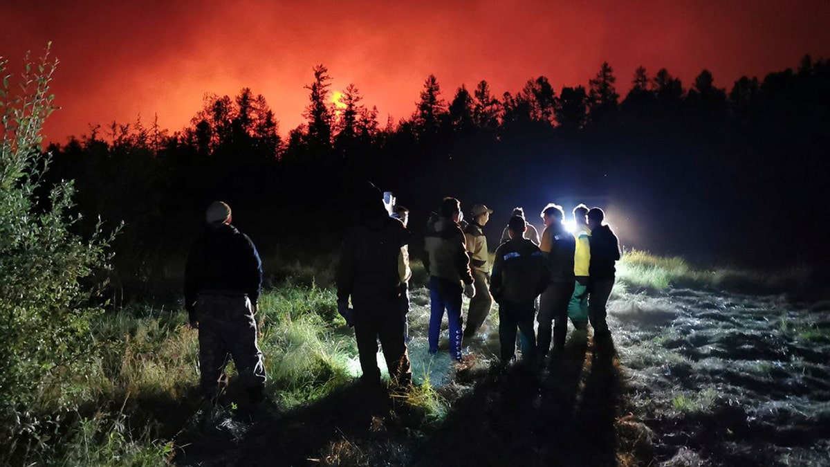 FILE - Firefighters and volunteers have a briefing as they work at the scene of forest fire at Gorny Ulus area west of Yakutsk, in Russia, Saturday, Aug. 7, 2021. (AP Photo/Ivan Nikiforov, File)