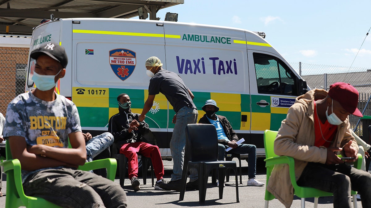 People wait to be vaccinated by a member of the Western Cape Metro EMS (Emergency Medical Services) at a mobile "Vaxi Taxi" which is an ambulance converted into a mobile COVID-19 vaccination site in Blackheath in Cape Town, South Africa, Tuesday, Dec. 14, 2021.  (AP Photo/Nardus Engelbrecht)