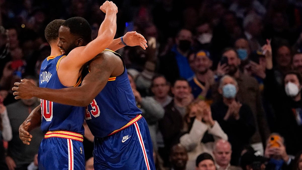 Golden State Warriors guard Stephen Curry (30) hugs forward Draymond Green (23) after scoring a 3-point basket during the first half of an NBA basketball game against the New York Knicks, Tuesday, Dec. 14, 2021, at Madison Square Garden in New York.