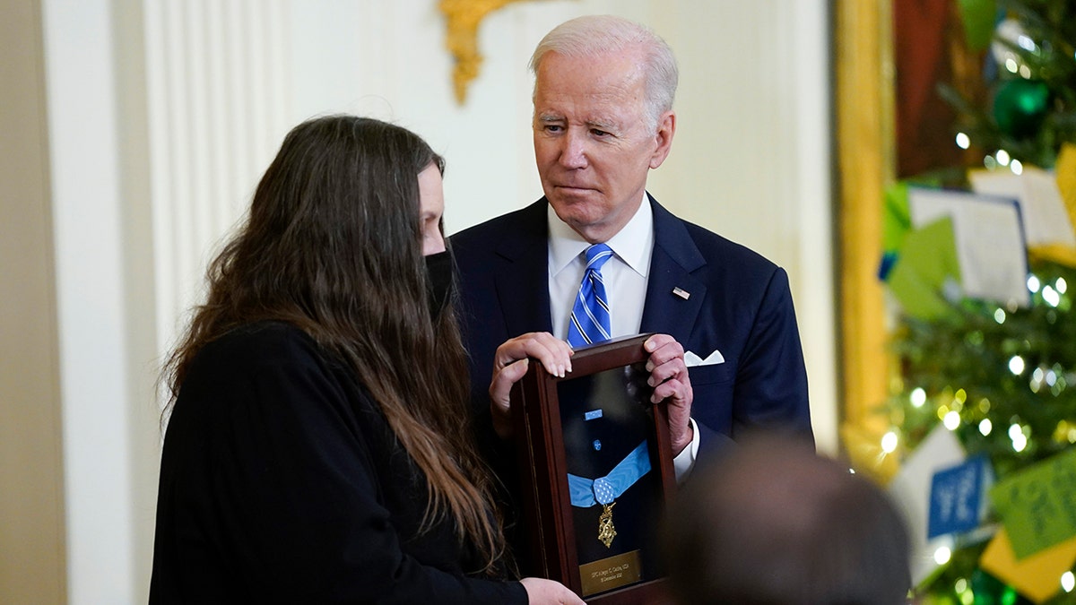 President Biden presents the Medal of Honor to Army Sgt. First Class Alwyn C. Cashe for his actions in Iraq on Oct. 17, 2005, as his widow, Tamara Cashe, accepts the posthumous recognition during an event in the East Room of the White House, Thursday, Dec. 16, 2021, in Washington. 