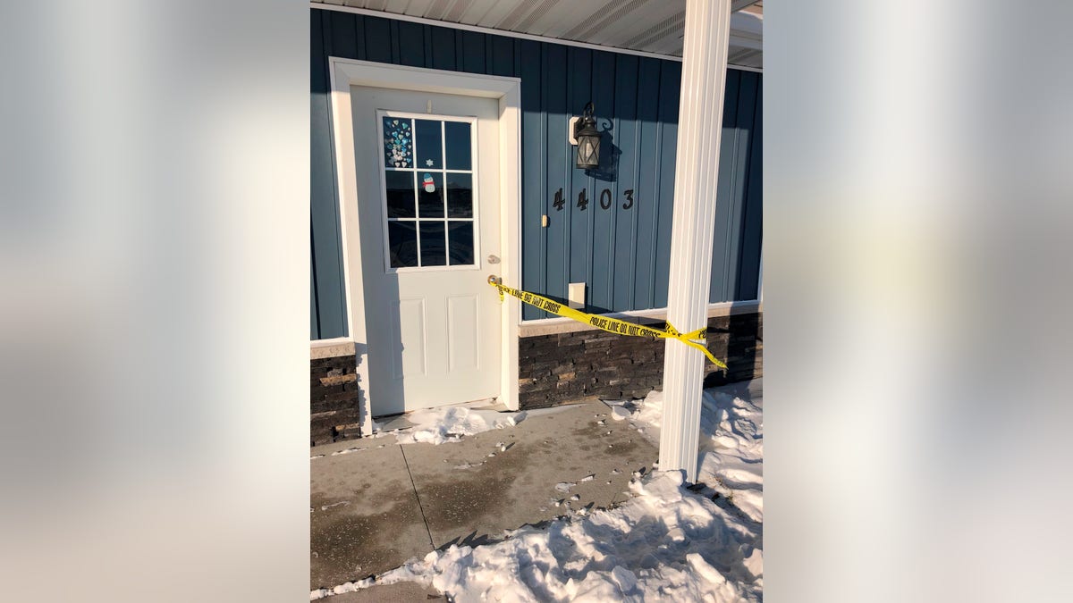 Police tape remained attached to the door of this twin home in Moorhead, Minn., on Monday, Dec. 20, 2021, marking the site where seven bodies were discovered by people conducting a welfare check.