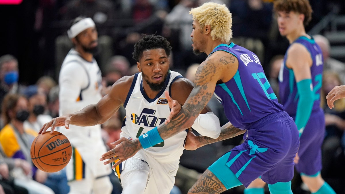 Charlotte Hornets guard Kelly Oubre Jr. defends against Utah Jazz guard Donovan Mitchell, Dec. 20, 2021, in Salt Lake City. (AP Photo/Rick Bowmer)