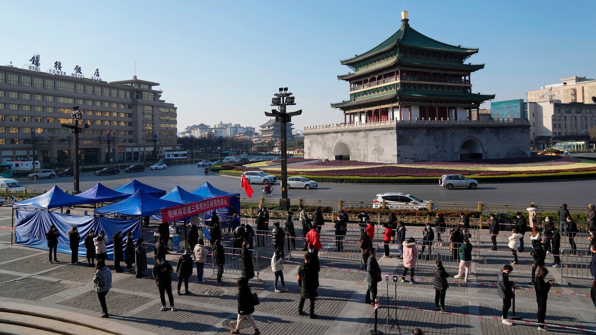 In this photo released by China's Xinhua News Agency, residents line up for tests at a COVID-19 testing site in Xi'an in northwestern China's Shaanxi Province, Tuesday, Dec. 21, 2021. (Li Yibo/Xinhua via AP)