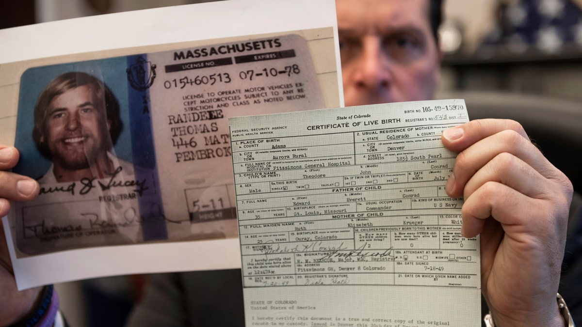 U.S. Marshal Peter J. Elliott holds the birth certificate and a copy of the driver's license of Ted Conrad on Dec. 16, 2021 at the Carl B. Stokes U.S. Courthouse in Cleveland. (AP Photo/Ken Blaze)