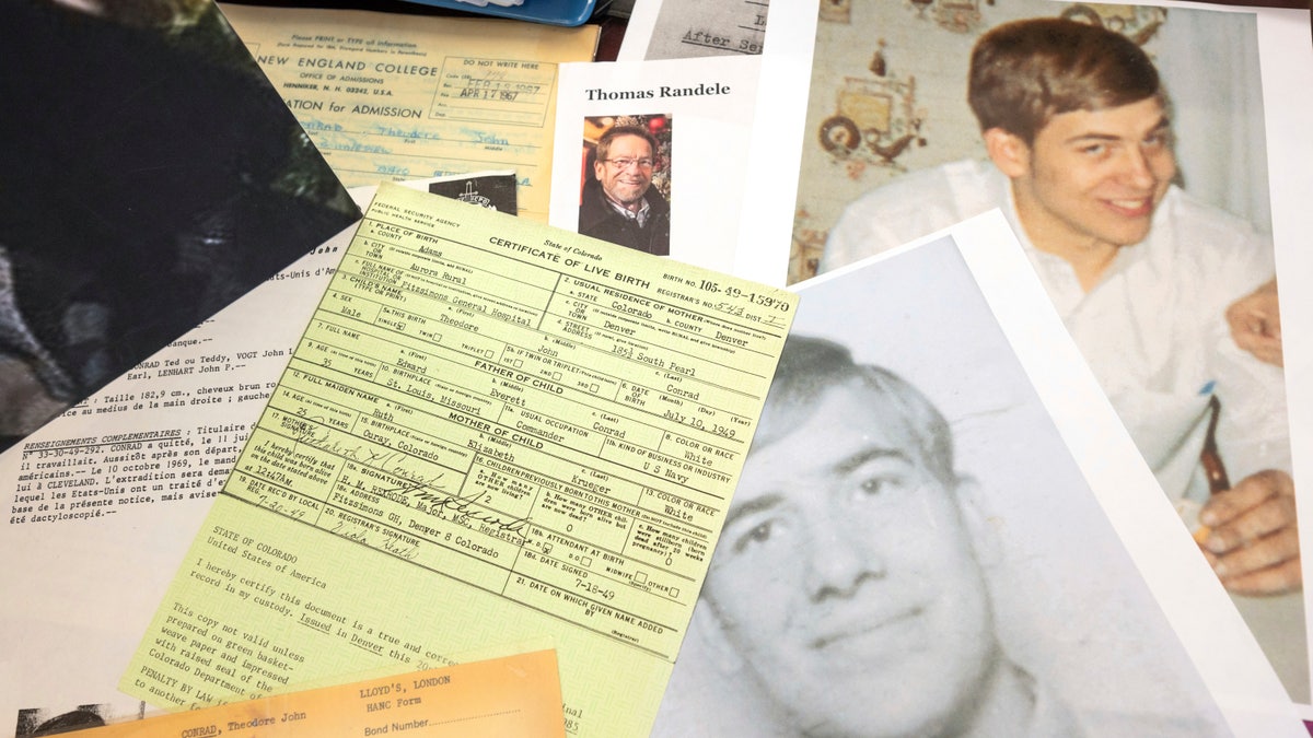 Photos, a driver's license, a death notice and other items from a 1969 robbery involving Ted Conrad are shown on Dec. 16, 2021 at the Carl B. Stokes U.S. Courthouse in Cleveland. After more than 50 years, Elliott announced that they had closed the case on one the city's biggest bank robberies. Conrad pulled off the 1969 robbery and had been living in Boston under a new name until his death last May, Elliott said. The U.S. Marshals Service is now piecing together how he managed to create new life while evading authorities. His stunned friends in Boston say he was a devoted family man and one of the nicest and most honorable people they'd ever known. (AP Photo/Ken Blaze)