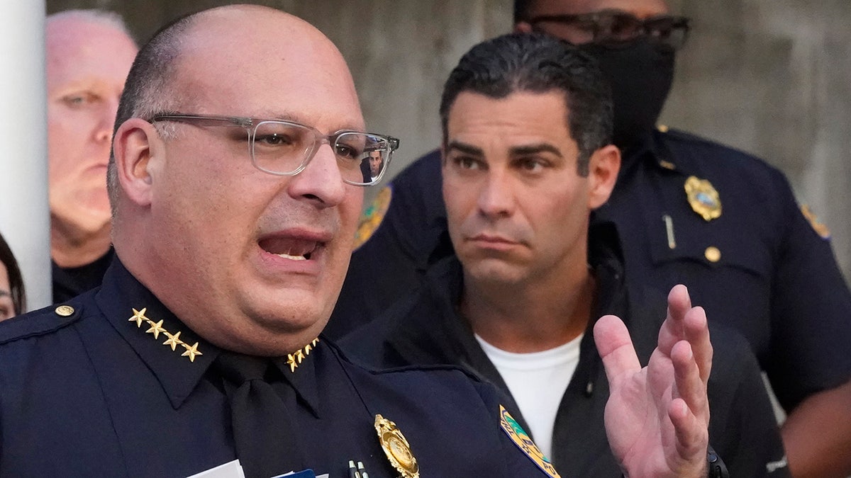 Miami Police interim Chief Manuel Morales, foreground and Mayor Francis Suarez, right, announce the arrest of a real estate agent suspected of hunting homeless people, Thursday, Dec. 23, 2021, during a news conference at the Miami Police Department in Miami. (AP Photo/Wilfredo Lee)