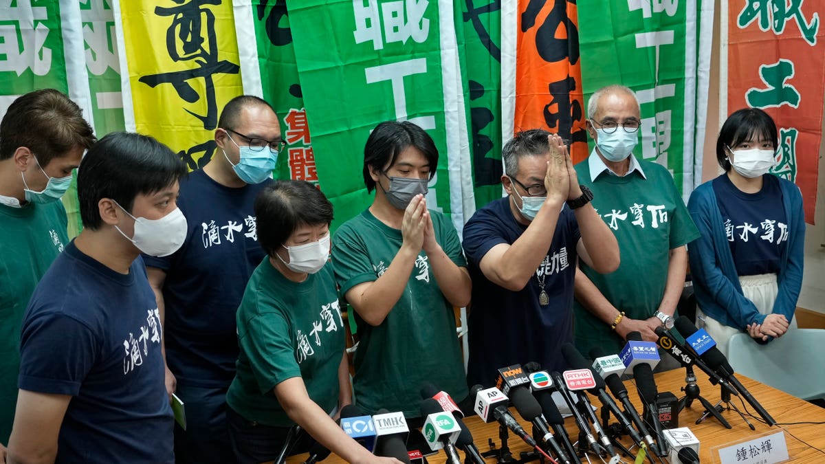Hong Kong Confederation of Trade Unions President Joe Wong Nai-yuen, third from right, with deep blue T-shirt, gestures while posing for a photo with other members before a news conference on the possibility of disbandment in Hong Kong Sunday, Sept. 19, 2021. (AP Photo/Vincent Yu, File)