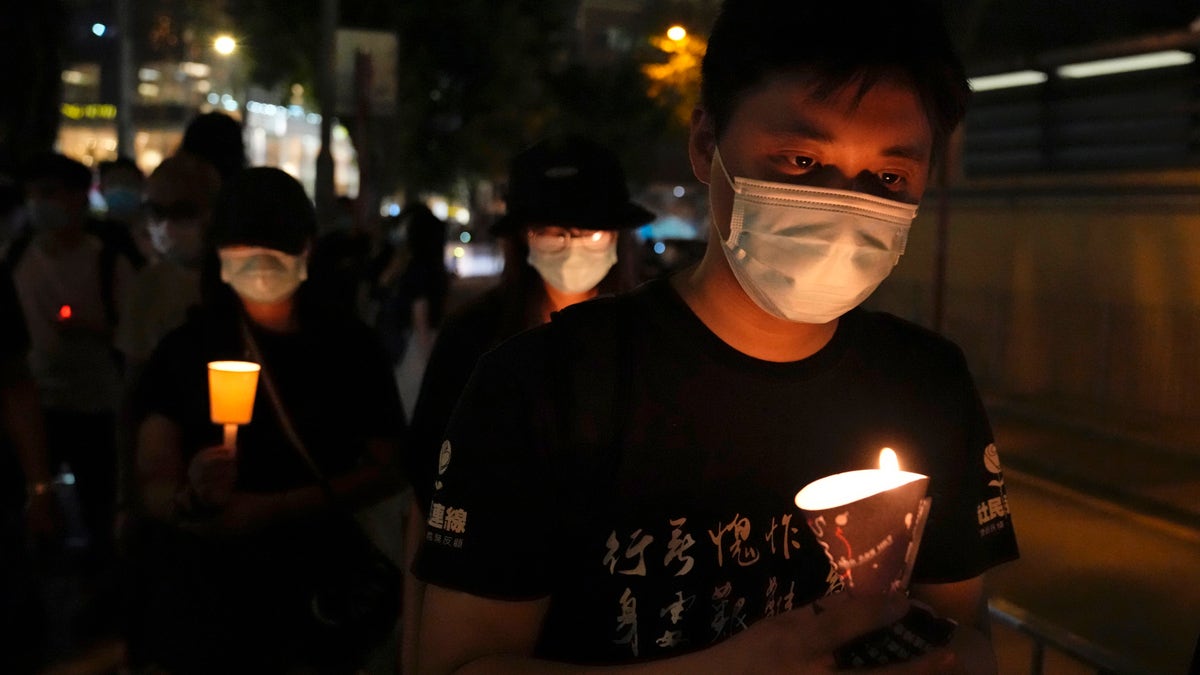 People walk with candles to mark the anniversary of the military crackdown on a pro-democracy student movement in Beijing, outside Victoria Park in Hong Kong, Friday, June 4, 2021. (AP Photo/Kin Cheung, File)