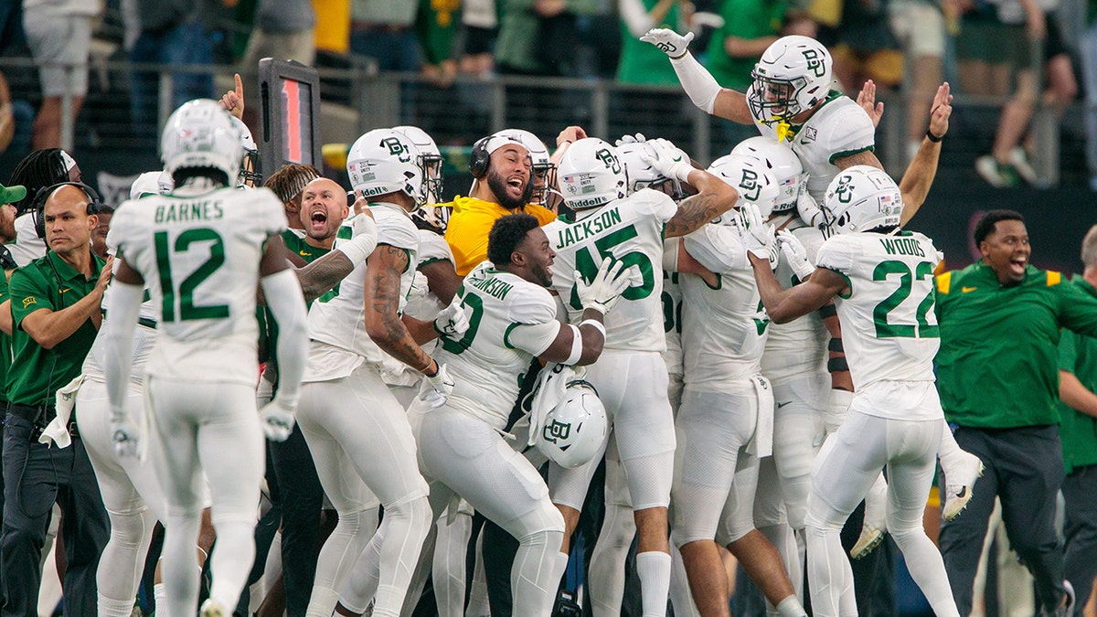 Baylor Bears players celebrate on the sidelines after a play against the Oklahoma State Cowboys Dec. 4th, 2021 in Arlington, Texas.