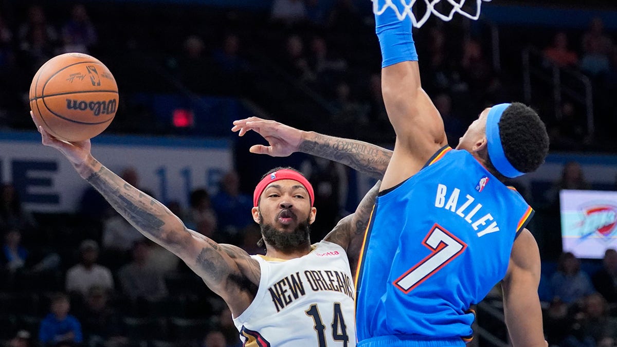 New Orleans Pelicans forward Brandon Ingram (14) passes around Oklahoma City forward Darius Bazley (7) in the second half of an NBA basketball game Wednesday, Dec. 15, 2021, in Oklahoma City. 