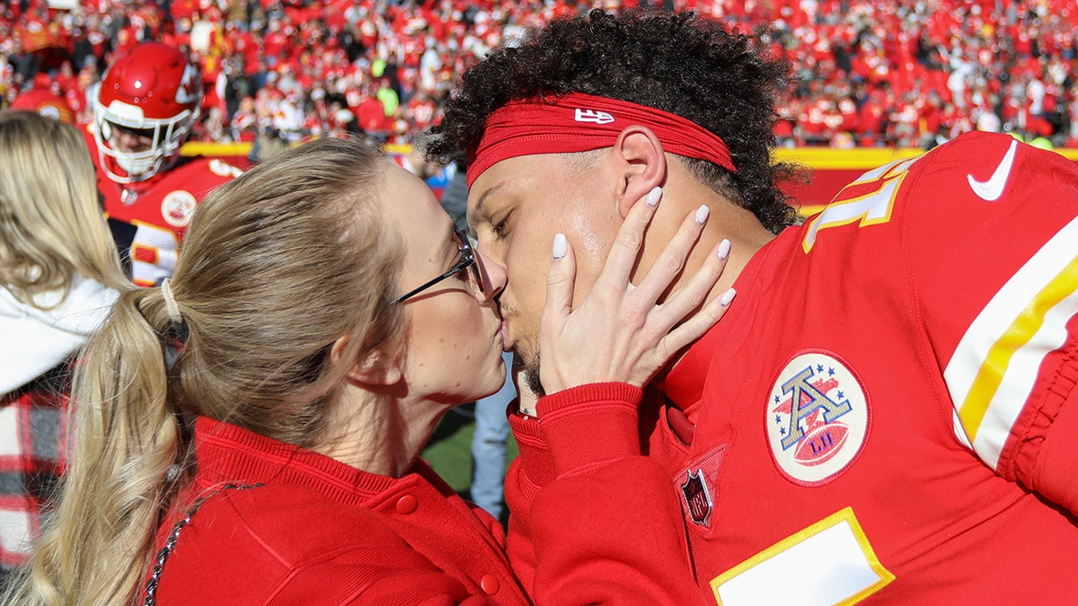 Patrick and Brittany Mahomes kissing on the field