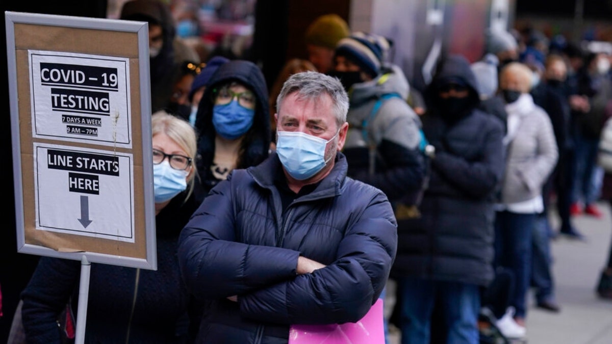 FILE - People wait in line at a COVID-19 testing site in New York' Times Square on Dec. 13, 2021. More than a year after the vaccine was rolled out, new cases of COVID-19 in the U.S. have soared to their highest level on record at over 265,000 per day on average, a surge driven largely by the highly contagious omicron variant. (AP Photo/Seth Wenig, File)