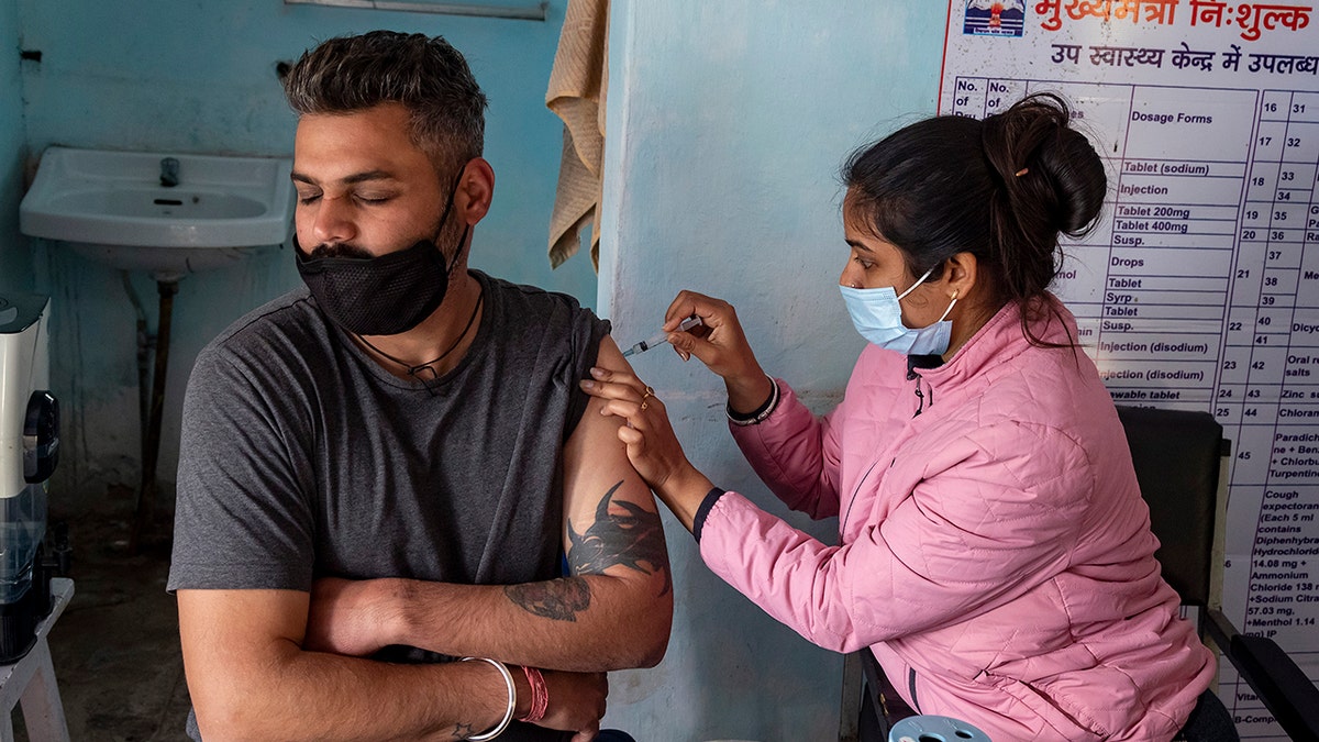 A man closes his eyes as he receives a Covishield vaccine for COVID-19 at a Primary Health Centre in Dharmsala, India, Friday, Dec. 3, 2021.